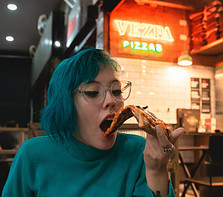 Image of a woman eating pizza