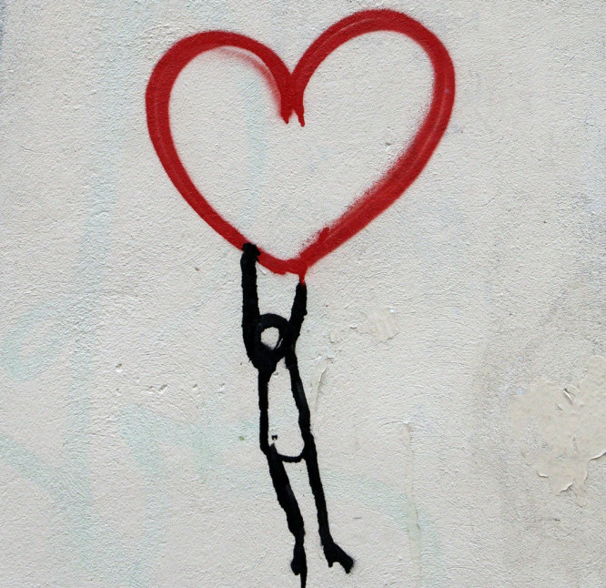 Hold on to your heart. Stick man floating off holding on to a red heart. 