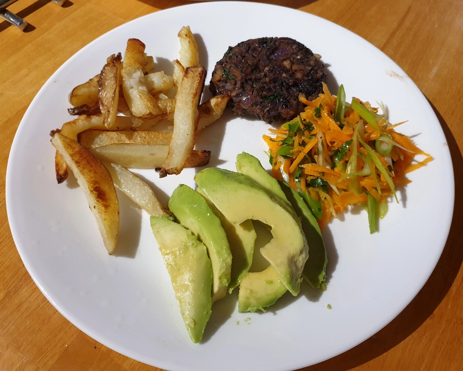 Mexican Black Bean Burgers, Carrot Slaw, Avocado & Fries plated up. 