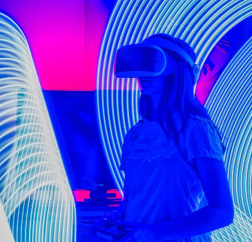 Woman with a VR headset on set against a vivid blue and pink background. 
