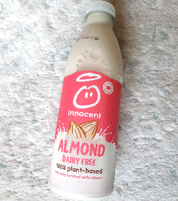 A bottle of Innocent brand almond milk. 