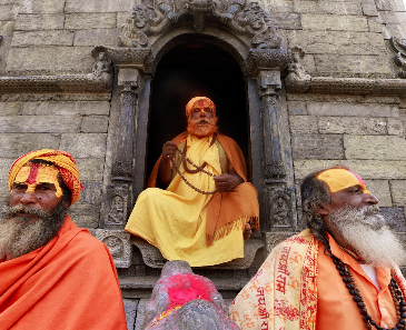 Jain elders against a stone temple backdrop. 
