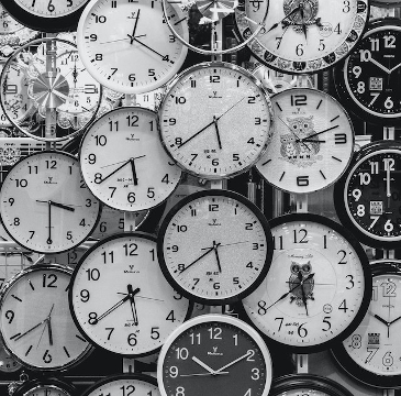 A multitude of clock faces, white and black. 