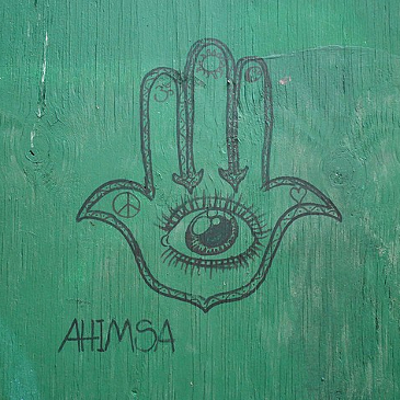 Graffiti featuring the word 'ahimsa' (non-violence) and symbols associated with Hinduism.