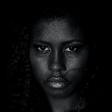 Greyscale photo of a woman looking directly at the camera with a stern expression on her face. 