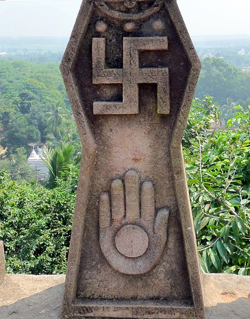 A stone carving of the swastika and Jain hand symbolising the importance of Ahimsa.