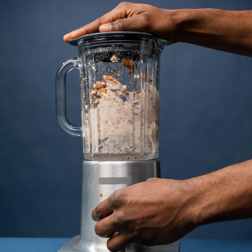 Making up a fresh batch of almond milk with a blender.