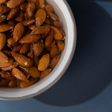 Close up of a bowl of almonds soaking in water ahead of making almond milk. 