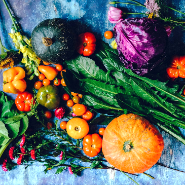 Lots of colourful vegetables on a blue background. 