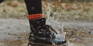 Vegan leather boot splashing in a puddle.
