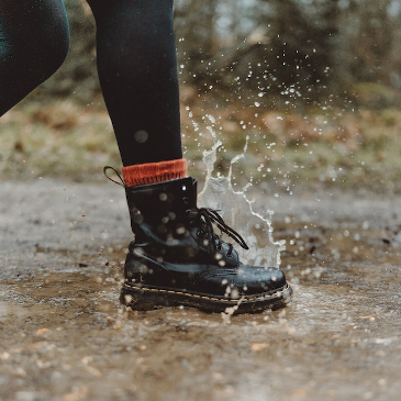 Vegan leather boot splashing in a puddle. 