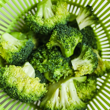 Close up of broccoli florets in a colander. 