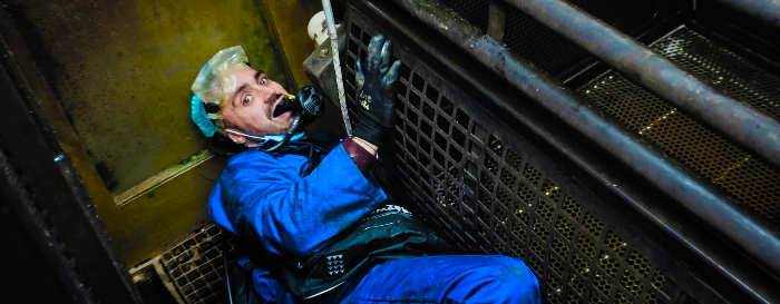 Joey in a blue boiler suit, using a respirator to descend into the gas chamber. 