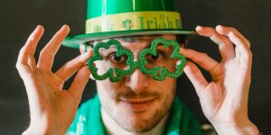 Man wearing shamrock shaped spectacles to celebrate St. Patrick's Day