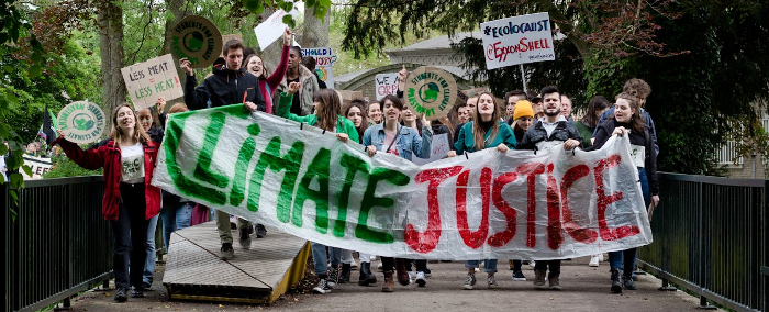 Climate activists on the march holding a big banner saying: 'climate justice' 