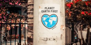 A poster of the world in a heart shape with the words "Planet Earth First"