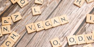 The word vegan spelled out using scrabble tiles.