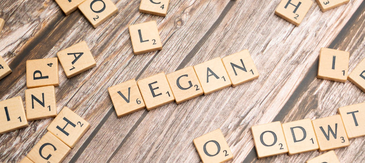 The word vegan spelled out using scrabble tiles.