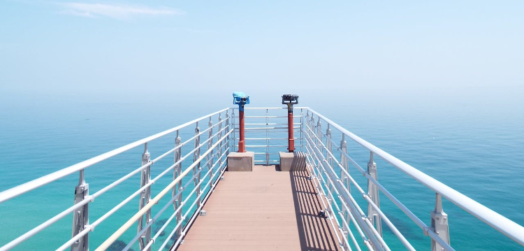 Looking out over a turquoise blue sea from a ship's gantry 